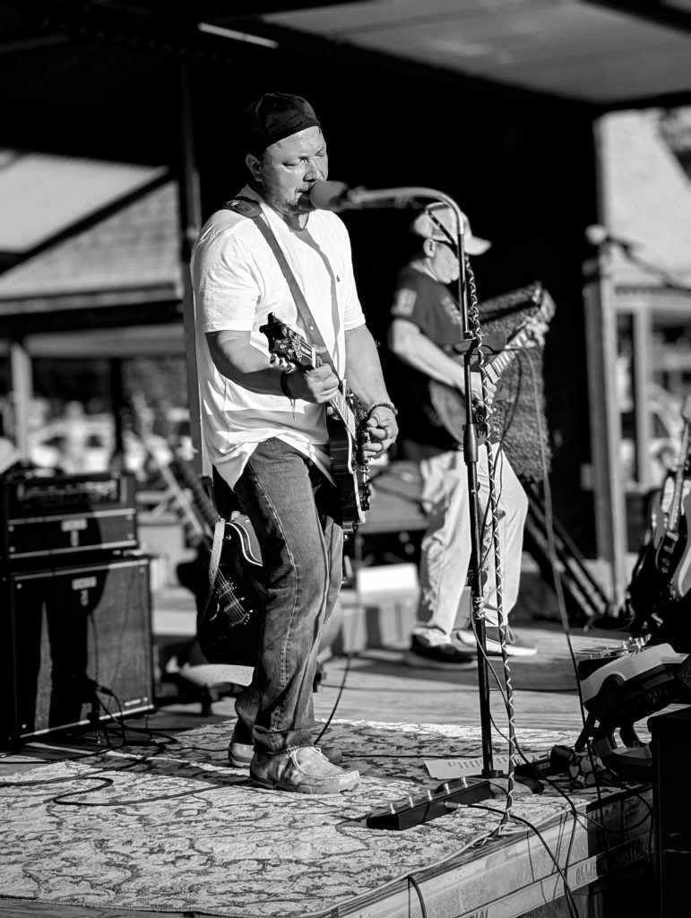 Brian Keene playing guitar at a concert.