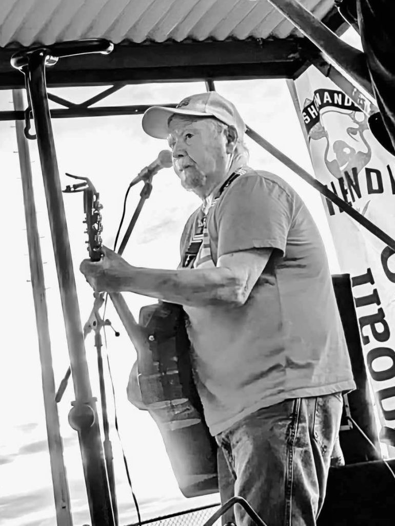 Webb Keene playing guitar at a concert.
